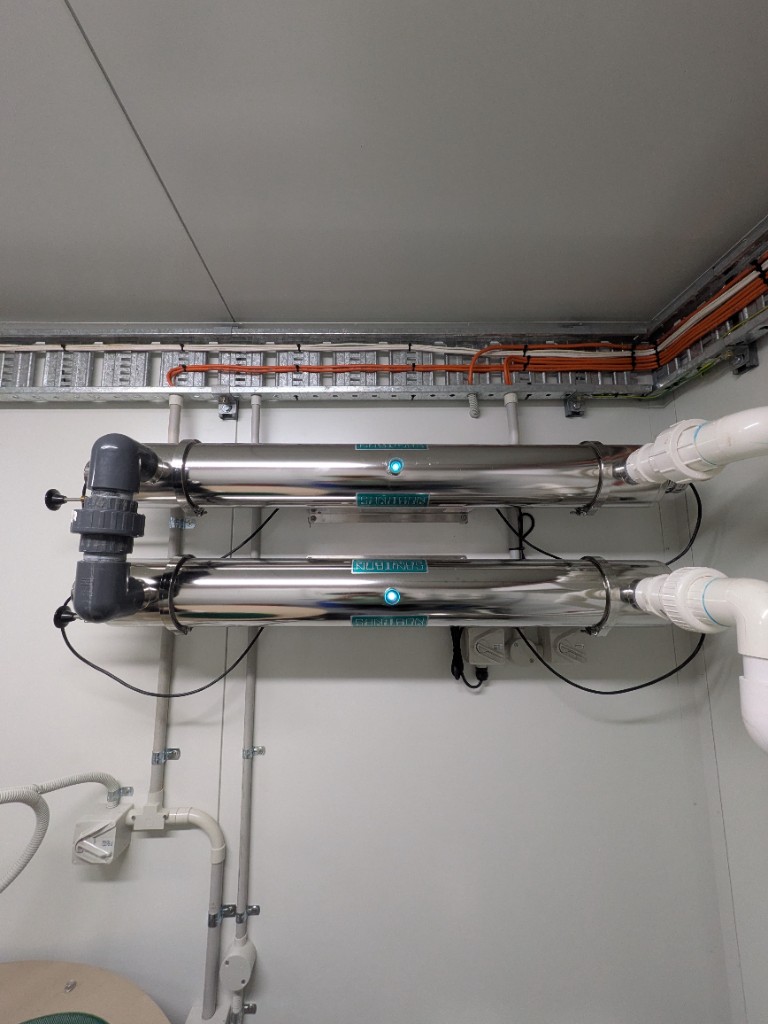 Twin Sanitron UV disinfection units on the WWTP control-room wall